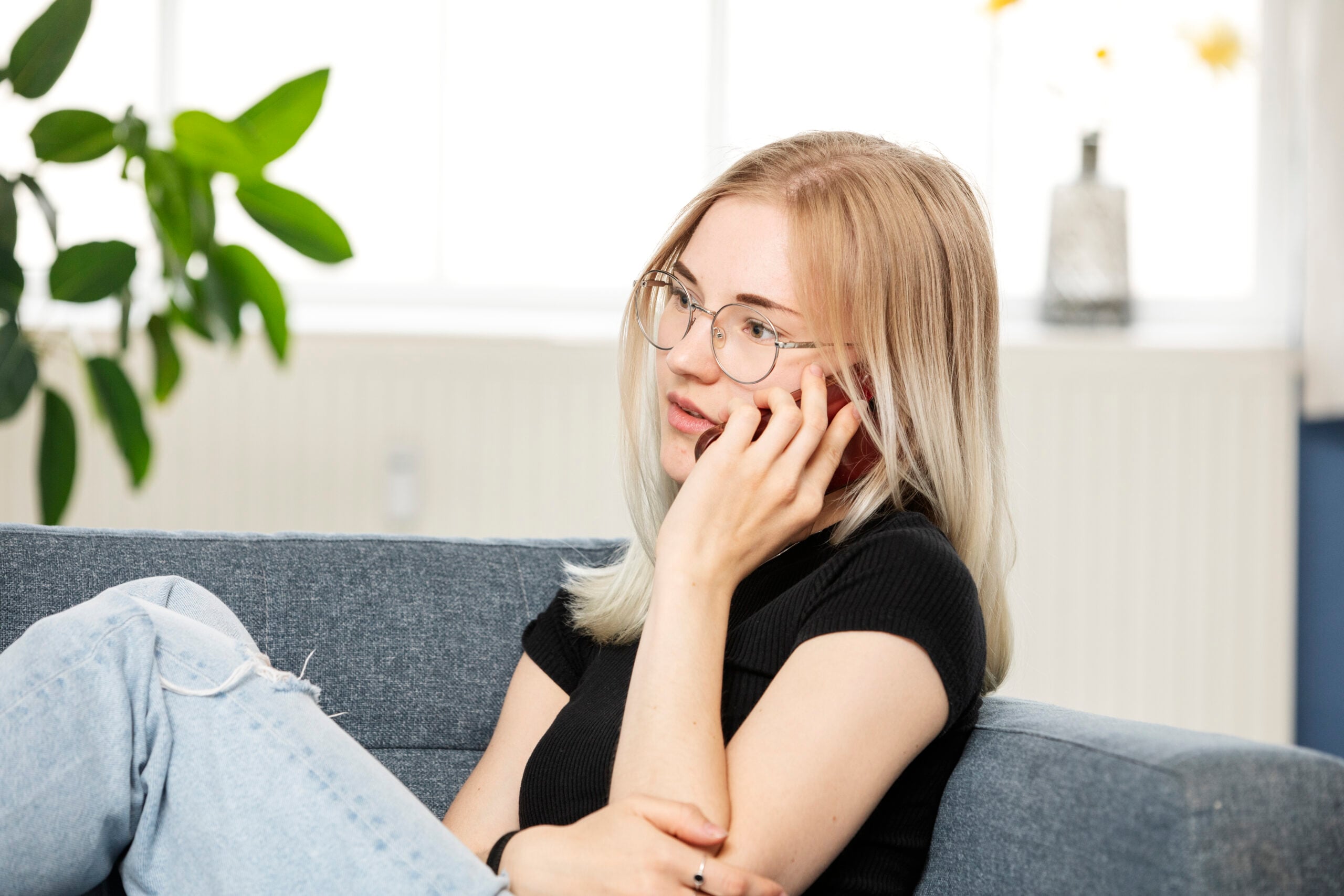 pige snakker i telefon i en sofa